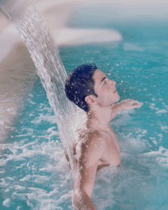 A man in a pool enjoys hydrotherapy benefits