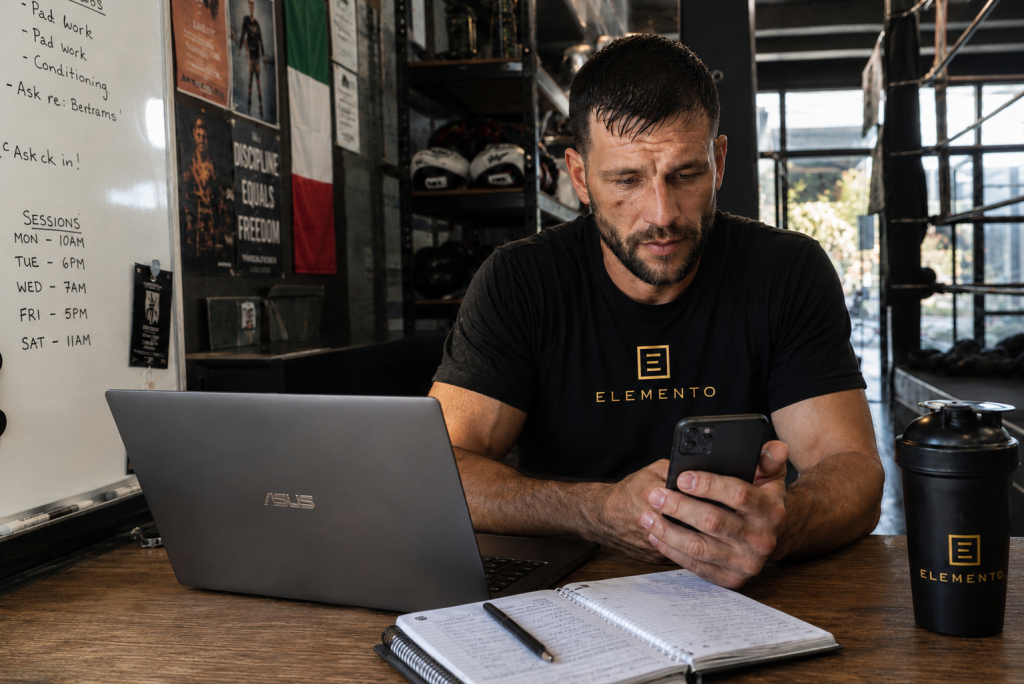 Self-employed boxing coach managing bookings and client messages after training, highlighting the business side of coach boxing salary UK.